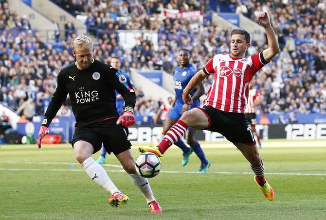 Southampton's Shane Long wins the ball as Leicester City's Kasper Schmeichel looks on