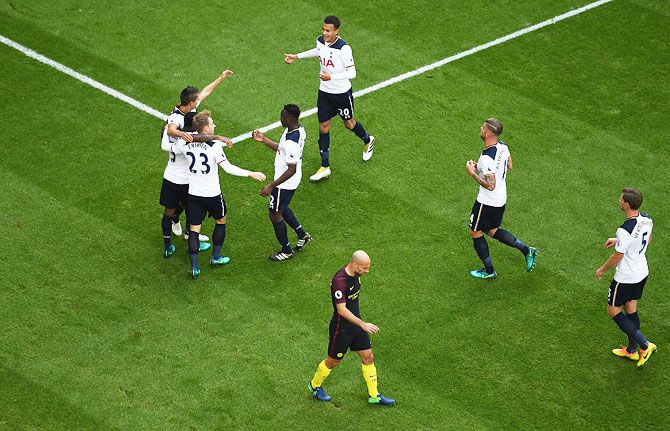 Tottenham Hotspur players celebrate their first goal after an own goal by Manchester City's Aleksander Kolorov during their English Premier League match at White Hart Lane in London on Sunday