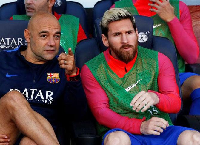 Barcelona's Lionel Messi sits on the bench