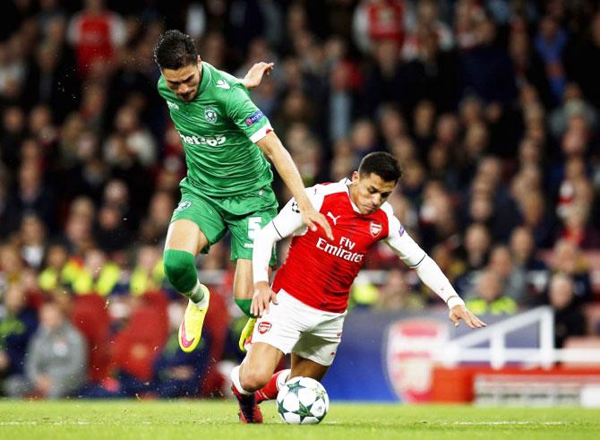 Arsenal's Alexis Sanchez and with PFC Ludogorets Razgrad's Jose Luis Palomino vie for possession