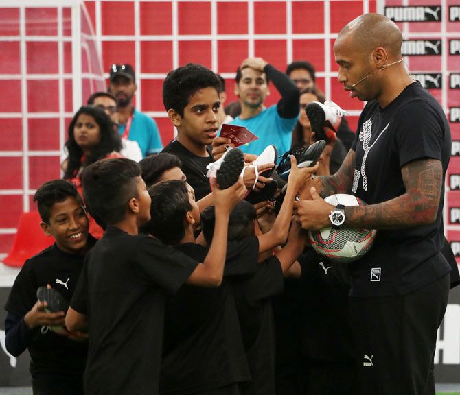 Thierry Henry obliges his young fans with autographs after the event