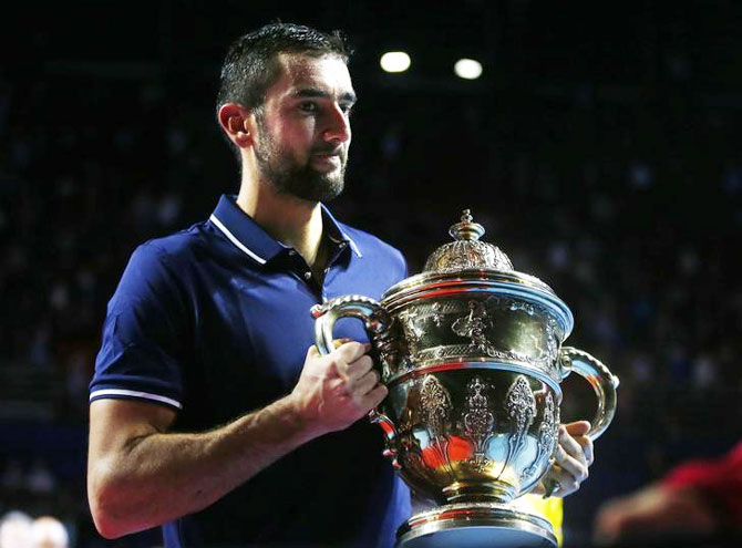 Marin Cilic of Croatia celebrates with the trophy after defeating Kei Nishikori of Japan to win the Swiss Indoors ATP title on Sunday