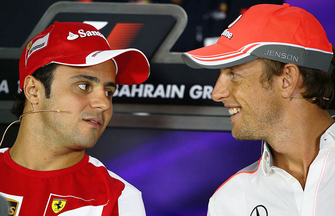 F1 drivers Felipe Massa and Jenson Button talk while attending the drivers press conference