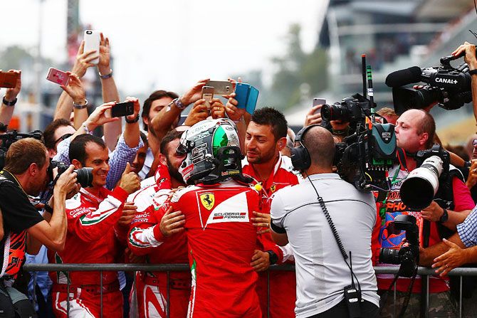 Ferrari's Sebastian Vettel celebrates with his team in parc ferme after a podium finish at Monza on Sunday