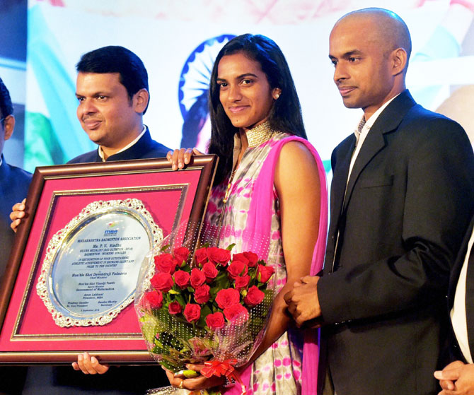  Maharashtra Chief Minister Devendra Fadnavis felicitates Olympic silver medallist shuttler P V Sindhu and her coach Gopichand in Mumbai on Tuesday