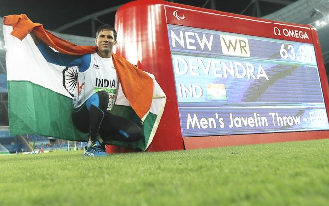 Devendra Jhajharia of India poses next to an information board showing his new world record at the 2016 Rio Paralympics