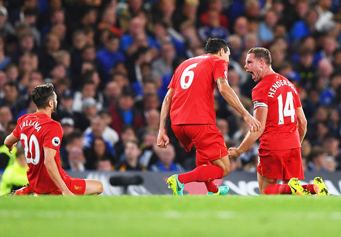 Jordan Henderson of Liverpool (right) is ecstatic after scoring a screamer against Chelsea and celebrates with teammates Dejan Lovren (6) and Adam Lallana during their English  Premier League match at Stamford Bridge in London on Friday