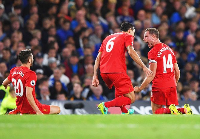 Jordan Henderson of Liverpool (right) is ecstatic after scoring a screamer against Chelsea and celebrates with teammates Dejan Lovren (6) and Adam Lallana during their English  Premier League match at Stamford Bridge in London on Friday