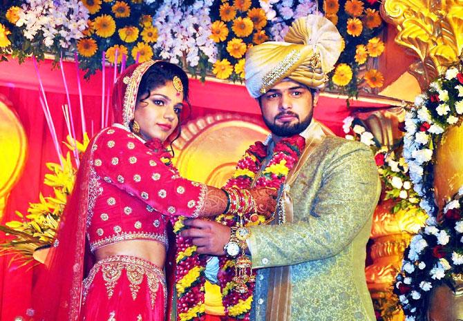 Indian wrestler Sakshi Malik with and her husband and fellow wrestler Satyawart Kadian exchange garlands during their wedding ceremony in Rohtak on Sunday