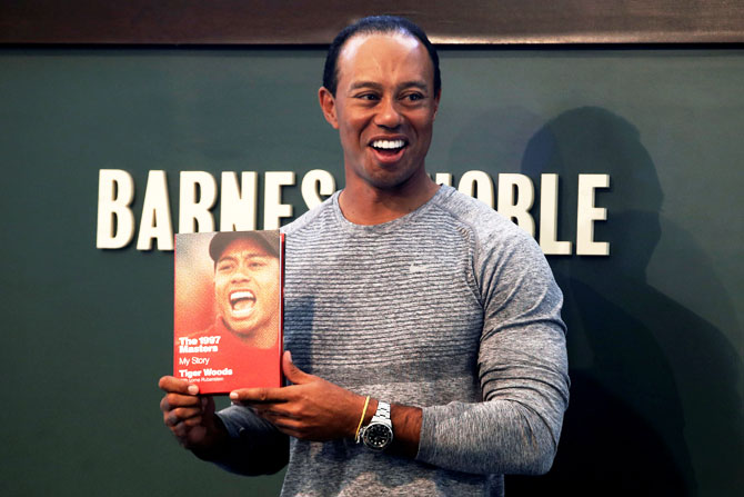 Golfer Tiger Woods poses with a copy of his new book "The 1997 Masters: My Story" at a book signing event at a Barnes & Noble store in New York City, New York, on March 20
