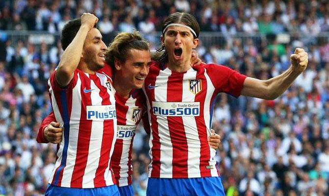 Atletico Madrid's Antoine Griezmann (centre) celebrates a goal with his teammates Angel Correa (left) and Filipe Luis during their La Liga match against Real Madrid at the Santiago Bernabeu Stadium, in Madrid on Saturday