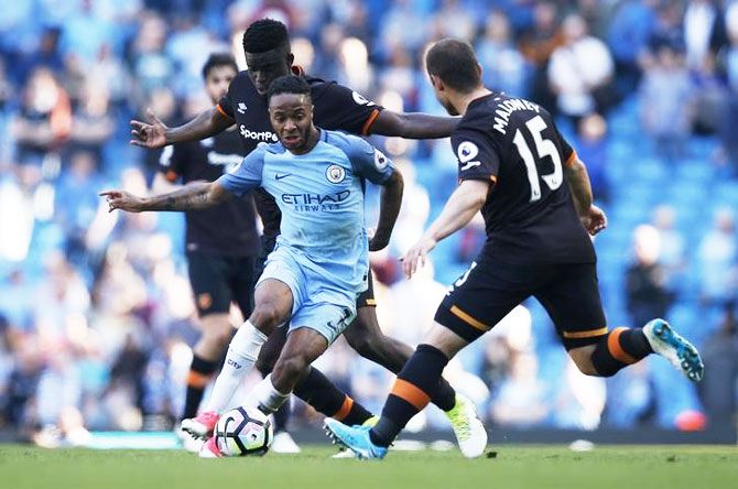 Manchester City's Raheem Sterling is challenged by Hull City's Alfred N'Diaye and Shaun Maloney as they vie for possession