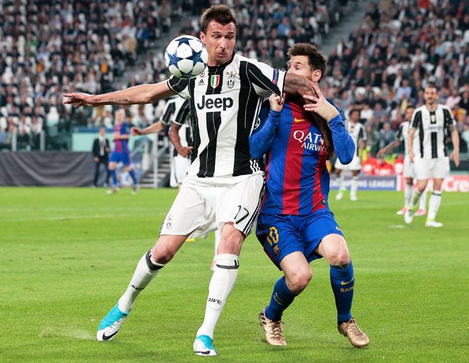 Juventus' Mario Mandzukic (left) and  Barcelona's Lionel Messi vie for possession during their Champions League quarter-final, first leg match at Juventus Stadium in Turin on Tuesday