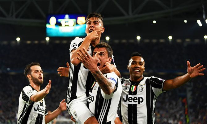 Juventus' Paulo Dybala celebrates with teammate Miralem Pjanic, Mario Mandzukic and Alex Sandro after scoring his team's second goal against Barcelona during their UEFA Champions League, quarter-final first leg match at Juventus Stadium in Turin on Tuesday