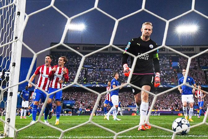 Atletico de Madrid's Antoine Griezmann celebrates with teammate Fernando Torres after scoring from  the penalty spot as Leicester City's Kasper Schmeichel retrieves the ball from the net during their UEFA Champions League quarter-final first leg match at Vicente Calderon Stadium in Madrid on Wednesday