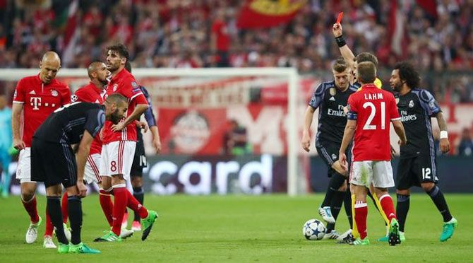 Bayern Munich's Javi Martinez is shown a red card by referee Nicola Rizzoli