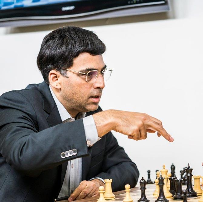 V. P. Kaushik, 11, watches as Indian World Rapid Chess Champion Viswanathan  Anand, unseen right, makes a move at the launch of a school chess  tournament organized by the NIIT Mind Champion's