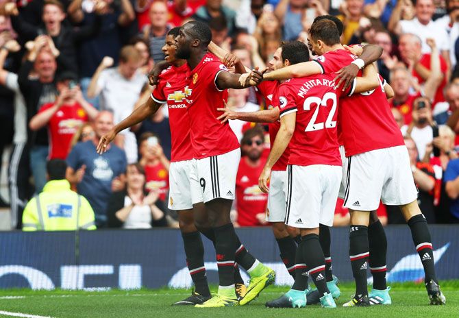 Manchester United's Romelu Lukaku celebrates with teammates after the first goal against West Ham United during their English  Premier League match at Old Trafford in Manchester on Sunday