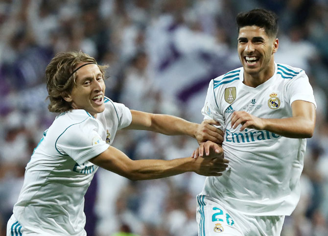 Real Madrid’s Marco Asensio celebrates with Luka Modric after scoring the first goal