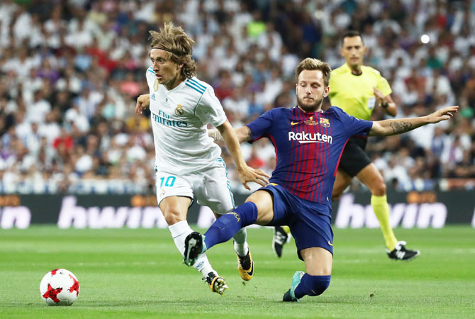 Barcelona’s Ivan Rakitic and Real Madrid’s Luka Modric vie for possession