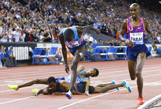 Britain's Mo Farah competes while Ethiopia's Yomif Kejelcha and Muktar Edris fall on the track