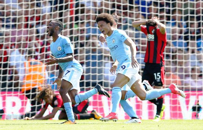 Manchester City's Raheem Sterling (left) and Leroy Sane celebrate scoring the winning goal against Bournemouth during their English Premier League match on Saturday