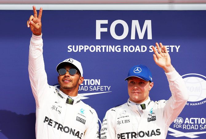 Mercedes' Lewis Hamilton celebrates his pole position next to teammate Valtteri Bottas after qualifying session at the Belgian Formula One GP in Spa-Francorchamps, Belgium, on Saturday