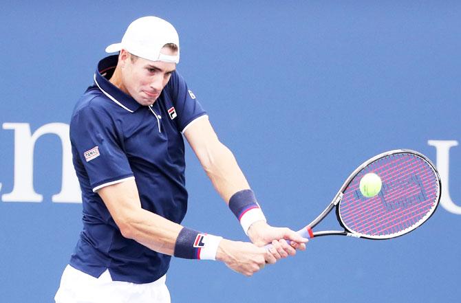 John Isner returns a shot during his first round match against Pierre-Hugues Herbert