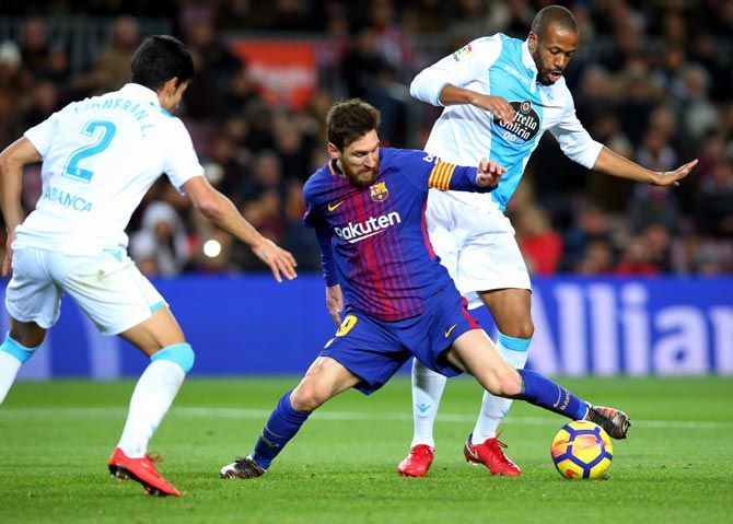 Lionel Messi tries to get the ball past Deportivo de La Coruna's Sidnei during a La Liga match