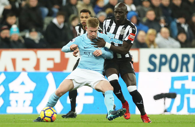 Manchester City's Kevin De Bruyne is challenged by Newcastle's Mohamed Diame