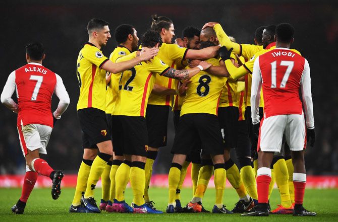 Watford's Younes Kaboul is mobbed by teammates after scoring the opening goal against Arsenal at Emirates Stadium on Tuesday