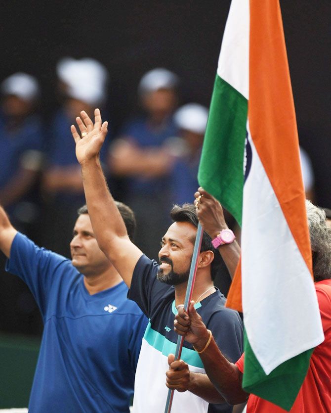 India's Leander Paes and captain Anand Amritraj (covered) celebrate after the team's Davis cup win over New Zealand in Pune on Sunday