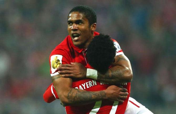 Bayern Munich's Douglas Costa celebrates his goal with David Aalaba against VFL Wolfsburg. during their German Cup match at Allianz Arena in Munich on Tuesday