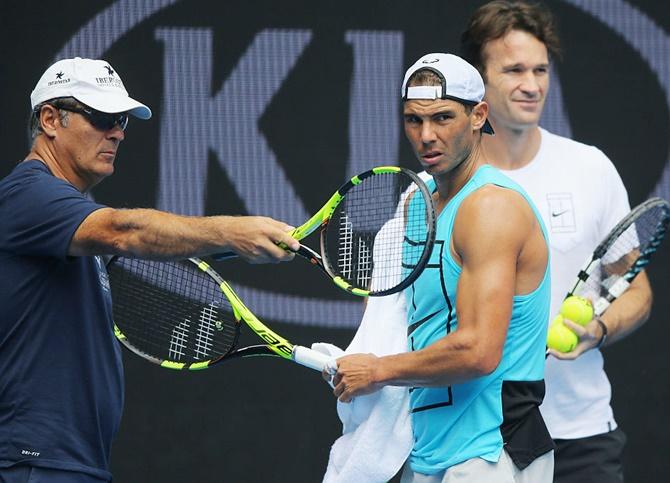  Nadal listens to coaches Toni Nadal,left, and Carlos Moya during a practice session