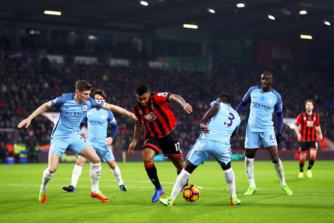 Bournemouth's Joshua King battles for the ball with Manchester City's Bacary Sagna and John Stones
