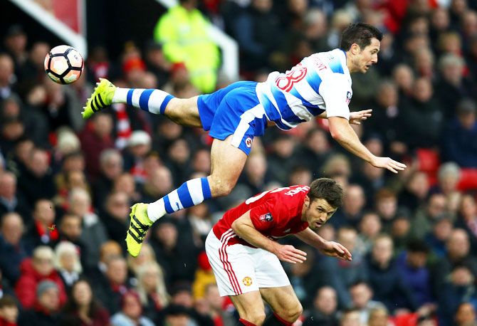 Reading's Yann Kermorgant goes airbone in a challenge against Manchester United's Michael Carrick