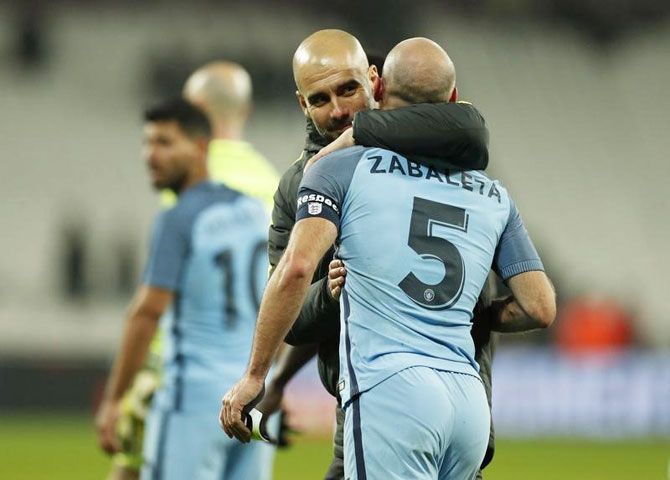 Manchester City manager Pep Guardiola celebrates with Pablo Zabaleta after the game