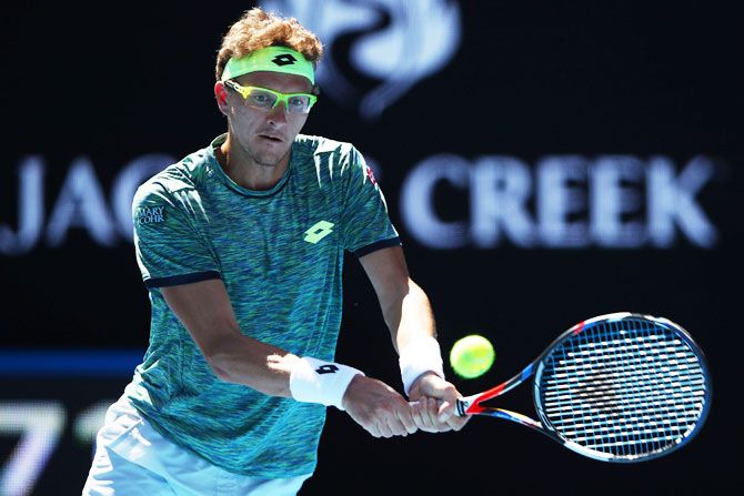 Denis Istomin plays a backhand return in his second round match against Novak Djokovic