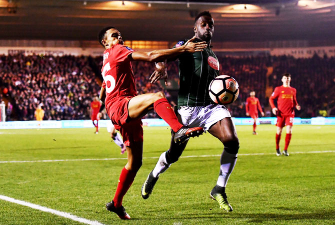 Liverpool's Trent Alexander-Arnold challenges Plymouth Argyle's Jordan Slew during The Emirates FA Cup third round replay match at Home Park in Plymouth, England, on Wednesday