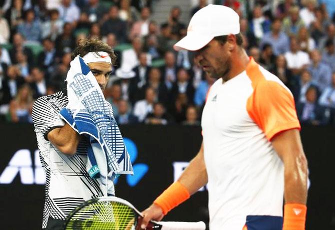 Germany's Mischa Zverev walks past Switzerland's Roger Federer during their Men's singles quarter-final match