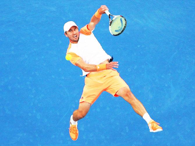 Mischa Zverev smashes a lob during his quarter-final against Roger Federer