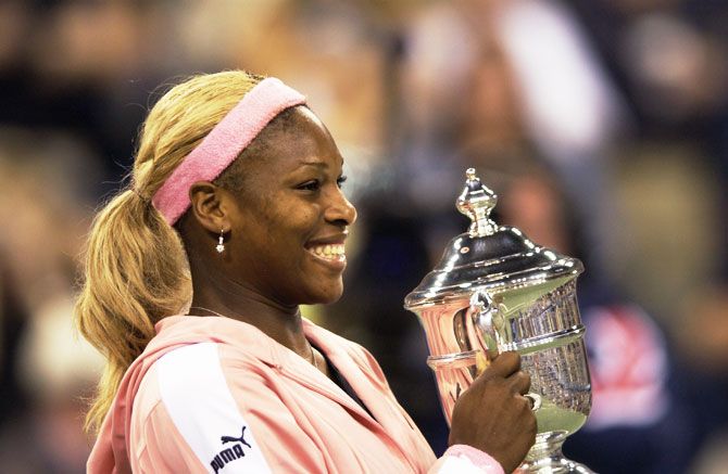 Serena Williams poses for photographers after defeating her sister Venus Williams to win the US Open final at the USTA National Tennis Center in Flushing Meadows-Corona Park, New York on September 7, 2002