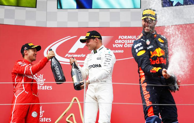 Mercedes' Valtteri Bottas celebrates his win on the podium with Ferrari's Sebastian Vettel and Red Bull's Daniel Ricciardo (right)
