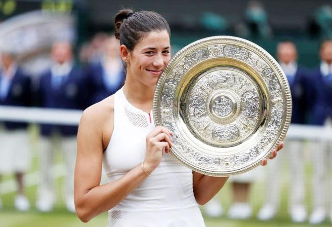 Spain’s Garbine Muguruza poses with the trophy as she celebrates winning the Wimbleodon final on Saturday