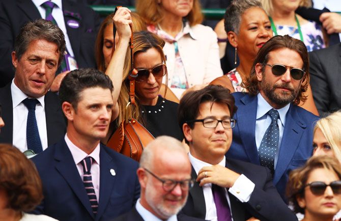 Hollywood actors Hugh Grant (behind, left), Bradley Cooper (behind, right), actor and comedian Michael McIntyre (front, right) and American golfer Justin Rose watch the Wimbledon men's final between Roger Federer and Marin Cilic at the All England Club on Sunday