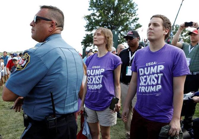 A security official keeps watch as the anti-trump protestors gather at the US Open Women's Golf tournament