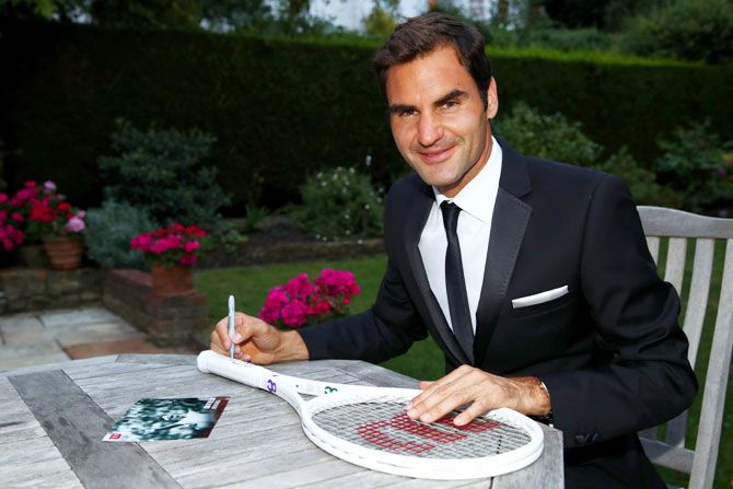 Roger Federer celebrates his Wimbledon record with an exclusive commemorative '8' Wilson tennis racket on Sunday