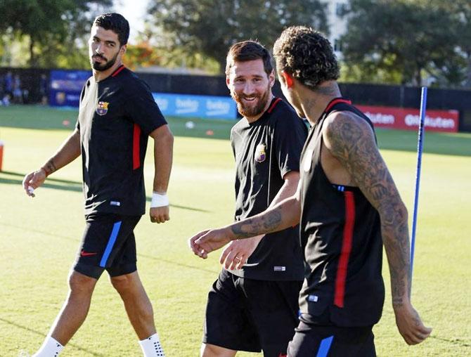 FC Barcelona's strike troika of Luis Suarez, Lionel Messi and Neymar walk out for a practice session