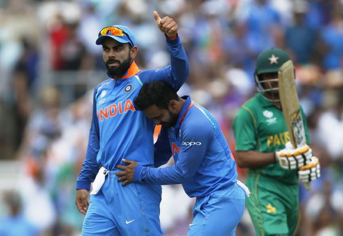 India’s Kedar Jadhav celebrates with Virat Kohli after taking the wicket of Pakistan's Babar Azam