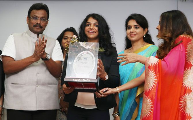 State Minister Sports, Youth Affairs and Education (Maharashtra), Vinod Tawde and BJP member and designer Shaina NC (right) present Saskhi Malik with the Woman of the Year Award at a function hosted by the Ladies' Wing of IMC Chamber of Commerce & Industry, in Mumbai on Wednesday